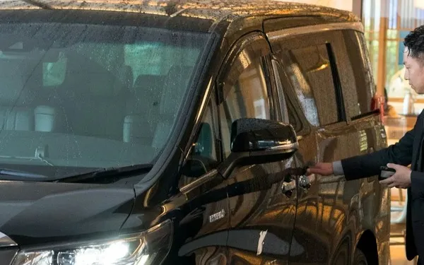 Chauffeur opening a luxury vehicle for airport transfer guests